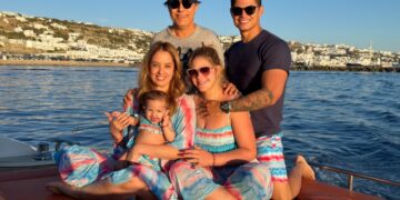 Cristiano curte férias em família em Mykonos ao lado de esposa, filha e sogrosO cantor Cristiano, da dupla sertaneja Jonatha e Cristiano, está aproveitando dias de descanso na Grécia ao lado da família. O artista viajou para Mykonos acompanhado da esposa, Maria Cavalcante, da filha do casal, Antonela, e dos sogros, o humorista Tom Cavalcante e Pati Lamounier.  Conhecida pelas praias paradisíacas, vida noturna movimentada e paisagens do mar Egeu, Mykonos é um dos destinos mais procurados da Europa durante o verão. Nas redes sociais, registros da viagem mostram momentos de lazer da família em cenários luxuosos da ilha grega.  Cristiano e Maria Cavalcante costumam compartilhar momentos da rotina familiar com os seguidores, incluindo viagens e bastidores da vida pessoal. A presença de Tom Cavalcante também chamou atenção dos fãs, que repercutiram os registros da viagem nas redes sociais.  O período de férias acontece em meio à agenda de shows da dupla Jonatha e Cristiano, que segue realizando apresentações pelo país em 2026.